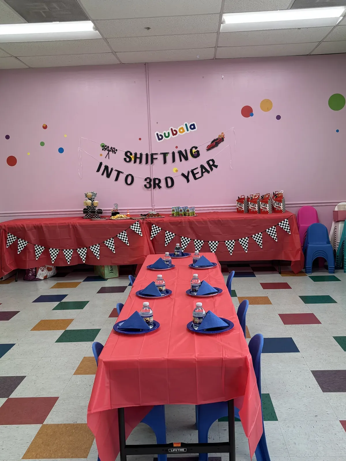 Wide view of red race-themed party tables