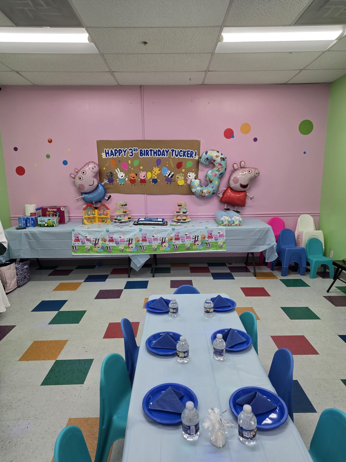 Peppa Pig party room with themed backdrop and balloons