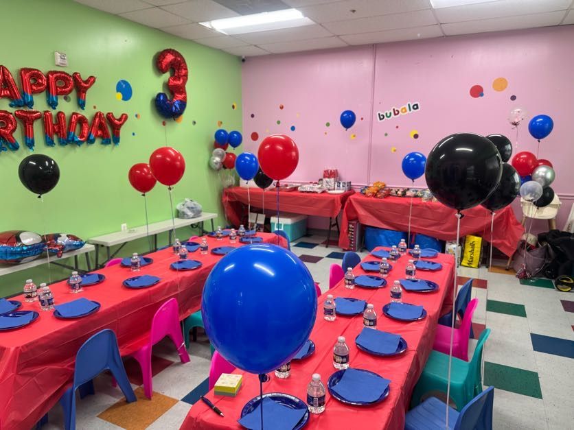 Spider-Man party room with red tables and balloons